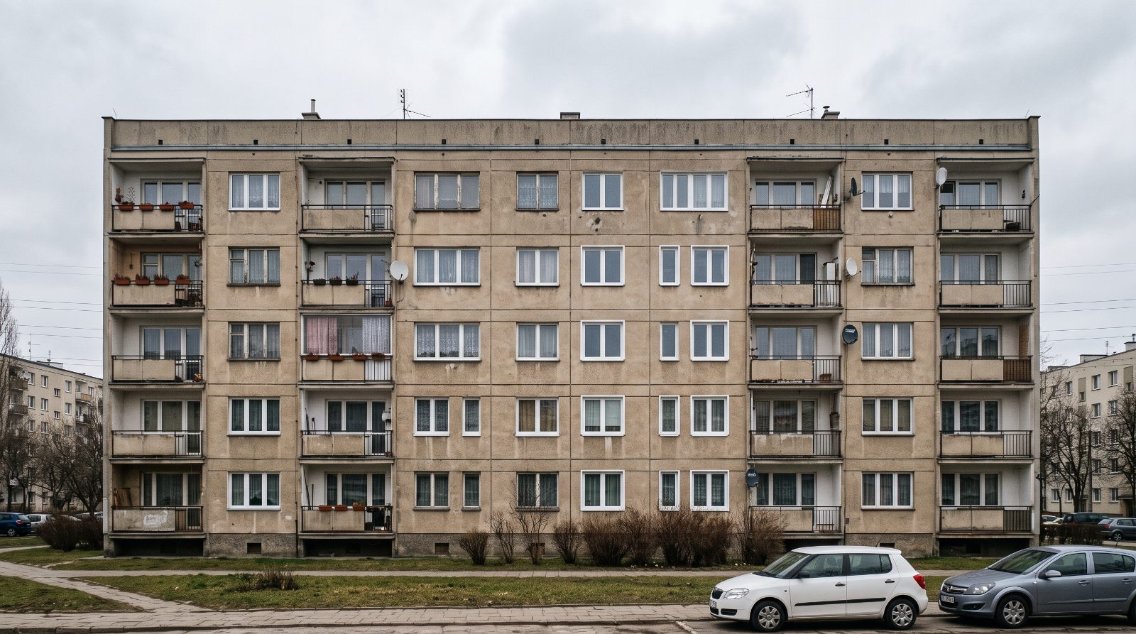 Elewacja bloku z częściowo wymienionymi oknami PCV